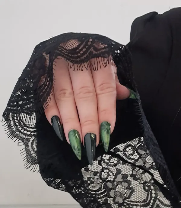 Long almond nails in black and green against black lace