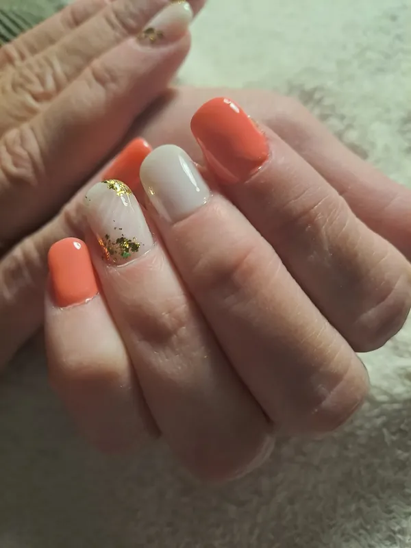 Short square nails in coral and white with gold leaf